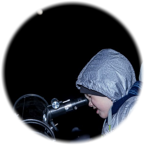 A child observing the Moon through a telescope